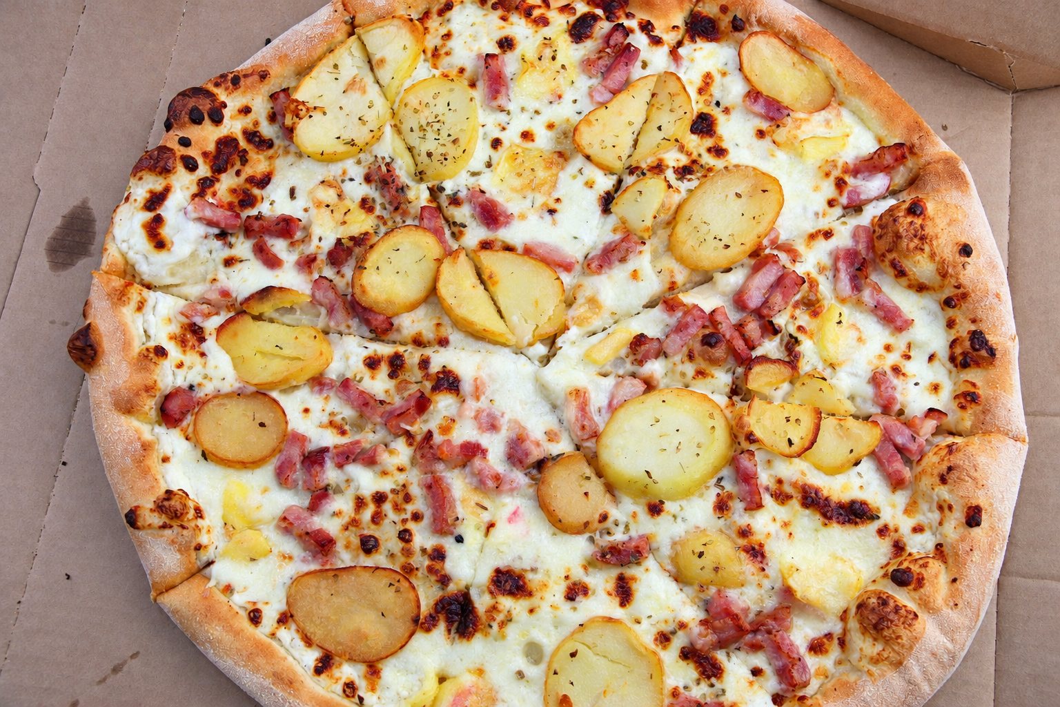 Pizza blanche aux pommes de terre et aux lardons, vue de dessus